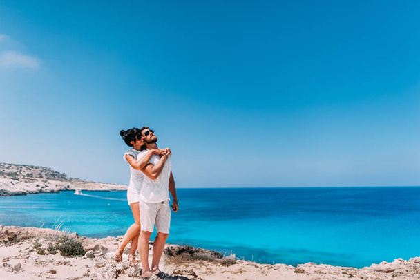 Happy couple by the sea. Man and woman hugging on the beach. Honeymoon lovers. Man and woman on the island. Couple in love on vacation. Sea tour. Honeymoon trip. Couple in love at the blue lagoon - Foto, imagen