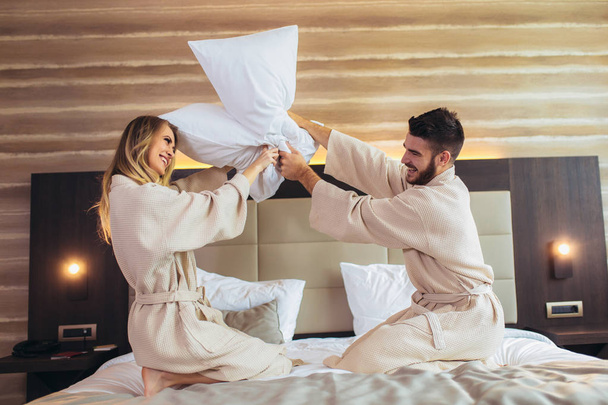 Happy Couple Having Pillow Fight in Hotel Room  - Foto, Imagem