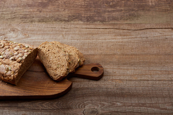 fresh cut bread loaf on chopping board on wooden table - 写真・画像