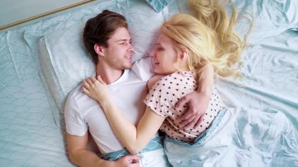 camera spin above loving couple lying in bed face to face in the morning - Filmagem, Vídeo