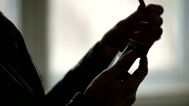 Close-up of the silhouette of female hands opening a pack of cigarettes and getting a cigarette from there. The grim concept of the harm of smoking in a low key - Footage, Video