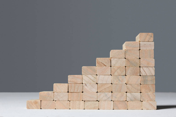 stairs build with wooden blocks on grey background - 写真・画像
