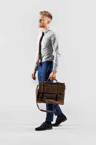 Going young businessman on grey background - Φωτογραφία, εικόνα