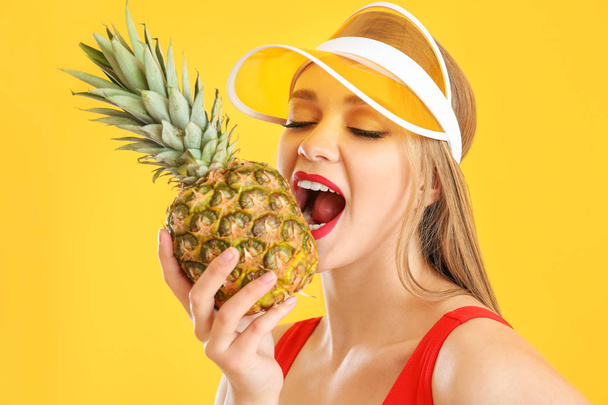 Beautiful young woman with pineapple on color background - Photo, Image