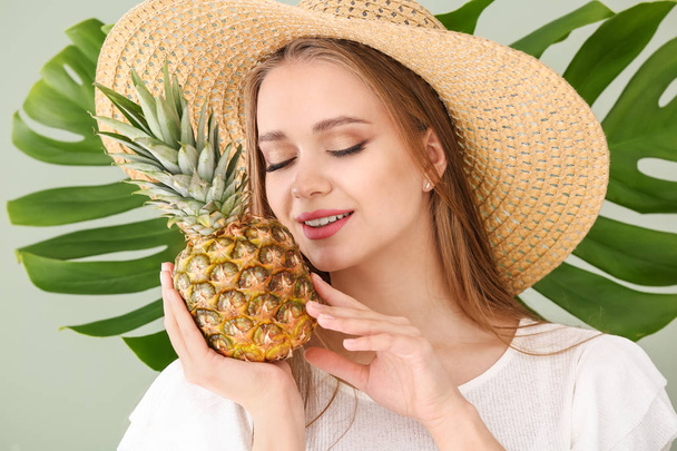 Renk arka planda ananas ve tropikal yaprak ile güzel genç kadın - Fotoğraf, Görsel