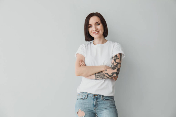 Stílusos tetovált nő a világos háttér - Fotó, kép