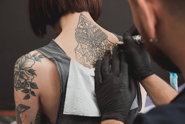 Professional artist making tattoo in salon - Фото, изображение
