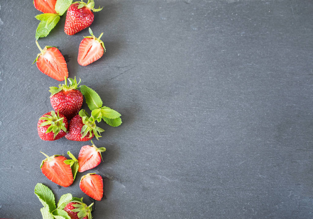 Fresh and juicy strawberries on a slate board background with empty space for text - Photo, Image