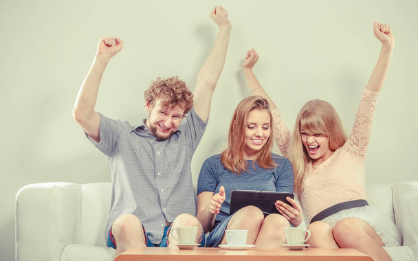 Successful happy friends with tablet at home. - Foto, Bild