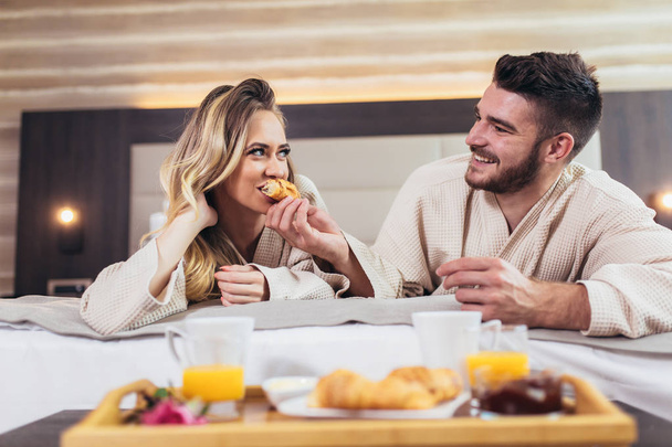 Mladý šťastný pár se snídaní v luxusním hotelovém pokoji.  - Fotografie, Obrázek