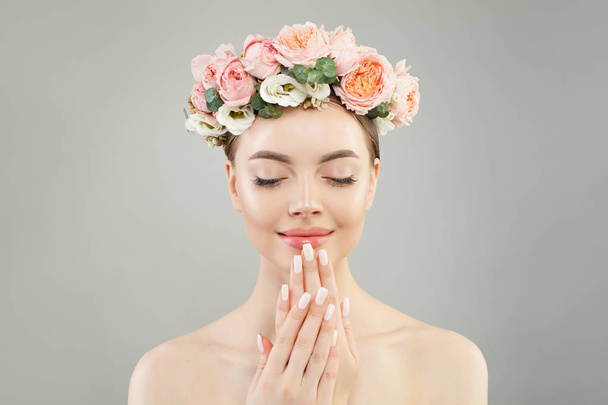 perfekte junge Frau mit klarer Haut und Rosenblüten auf weißem Grund  - Foto, Bild