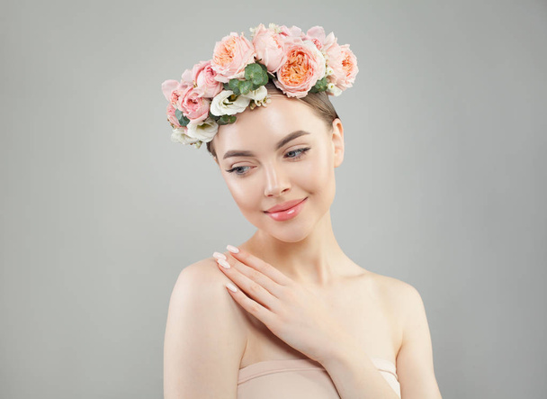 Mooi model met heldere huid en bloemen op witte achtergrond - Foto, afbeelding