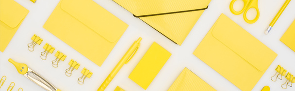 панорамный снимок желтой ручки, карандашей, скрепки, ластика, наклейки, конверты, наклейки, папки, ножницы и компасы, изолированные на белом
 - Фото, изображение