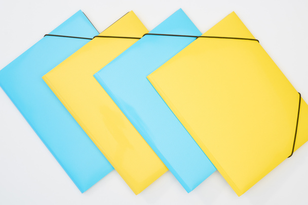 flat lay of yellow and blue folders on white background - Foto, Imagem