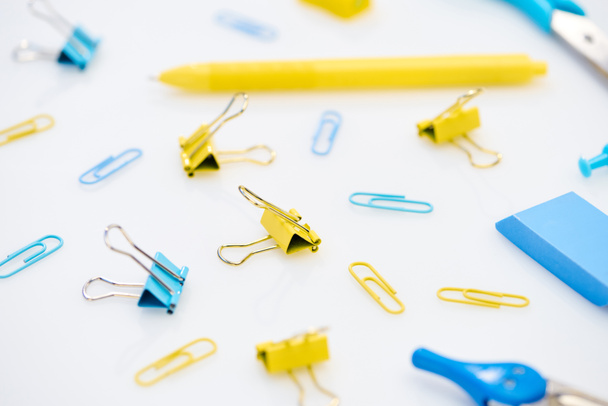 selective focus of colourful paper clips and other stationery on white background  - Foto, immagini