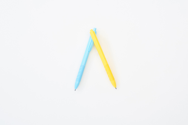 Κορυφαία όψη των κίτρινων και μπλε μολυβιών που απομονώνονται σε λευκό - Φωτογραφία, εικόνα