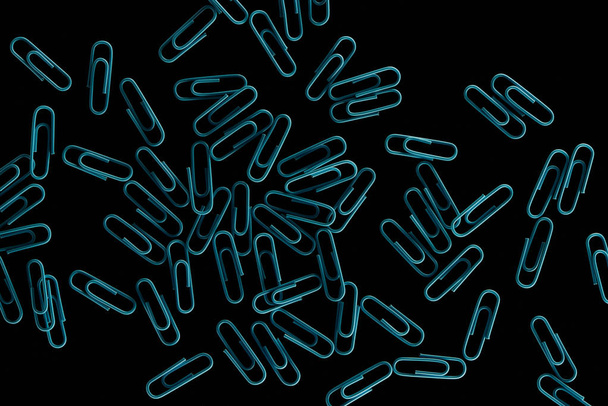 top view scattered blue paper clips isolated on black  - Foto, imagen