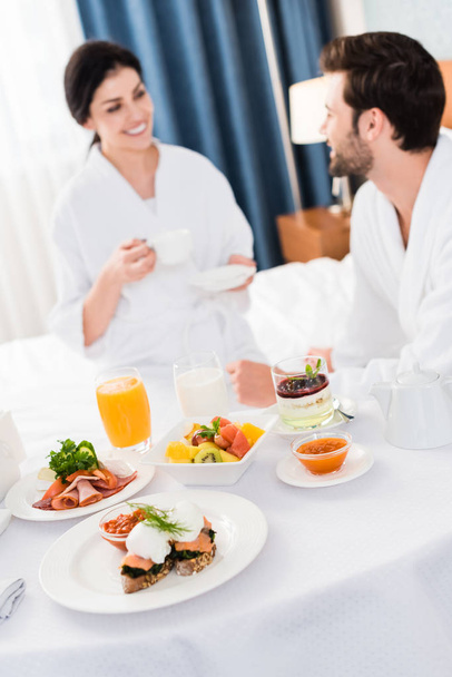 selective focus of delicious breakfast near happy man and woman  - Фото, изображение