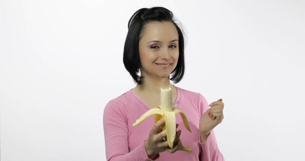 Young beautiful woman with a big banana. Offer bite to viewer - Photo, Image