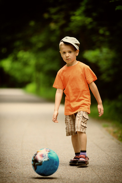 Boy kicks the ball in park outdoors - 写真・画像