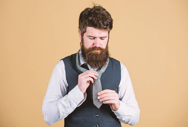 Different ways of tying necktie knots. Art of manliness. How to tie necktie. Start with your collar up and the tie around your neck. How to tie simple knot. Man bearded hipster try to make knot - Foto, afbeelding