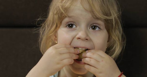 Девушка сидит на диване и ест кукурузные шарики. Детские мозоли на вкус
 - Фото, изображение