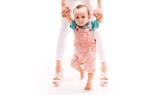 Helping baby learn to walk. Small child walking with help, motor skills. Little boy child develop gross motor activity. Toddler stage of development. Adorable small toddler. Little baby learn to walk - Photo, image