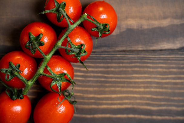 Verse cherry tomaten op een donkere houten achtergrond. - Foto, afbeelding
