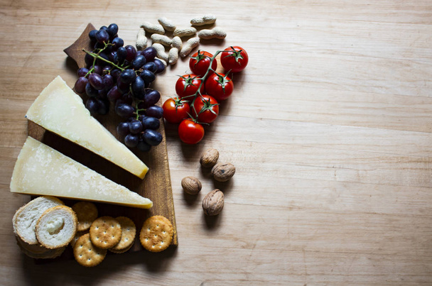 Cheese with grapes and cherry tomatoes, cracker, nuts, fruits an - Φωτογραφία, εικόνα