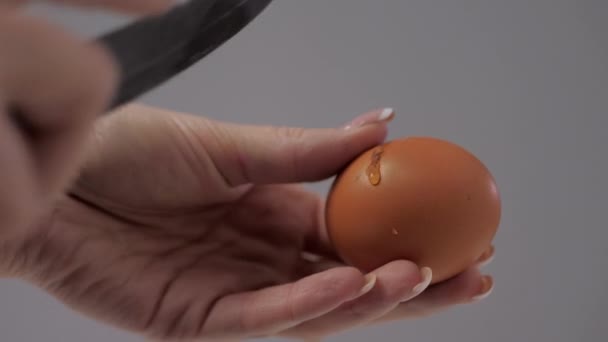 μαγειρεύει κορίτσι σπάει αυγό κοτόπουλο με ένα μαχαίρι κουζίνας - Πλάνα, βίντεο