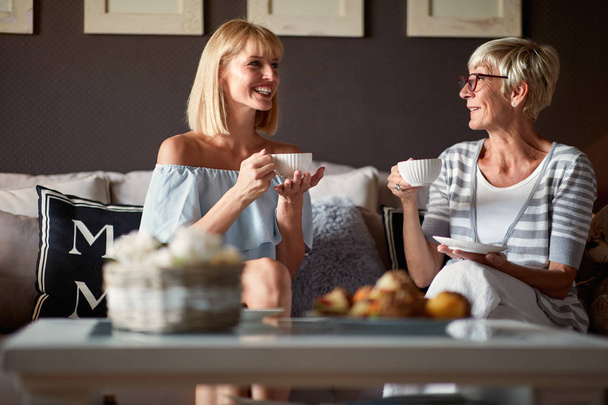 Senior female with young woman drinking coffee - Foto, Imagen