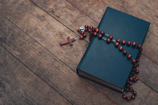 Old red Beads and crucifix on a Holy Bible background.  - 写真・画像