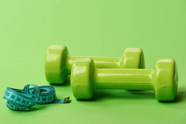 Dumbbells in bright green color on green background - Zdjęcie, obraz
