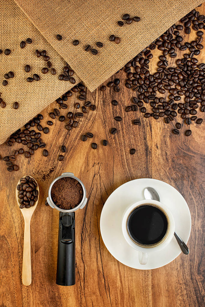 Kávéscsésze és pörkölt kávébab. a fából készült háttéren. - Fotó, kép