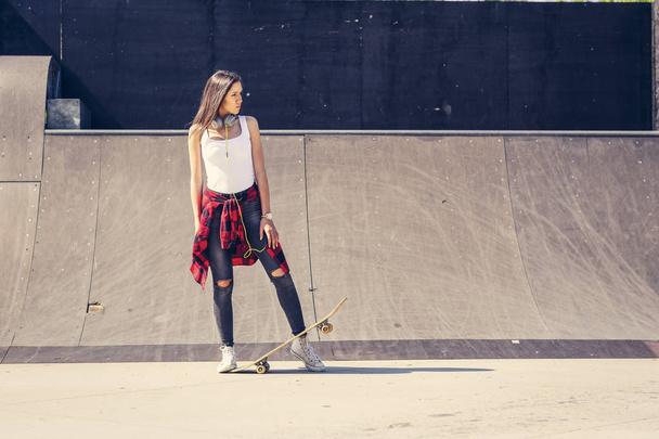 Menina bonito segurando skate no parque de skate
 - Foto, Imagem