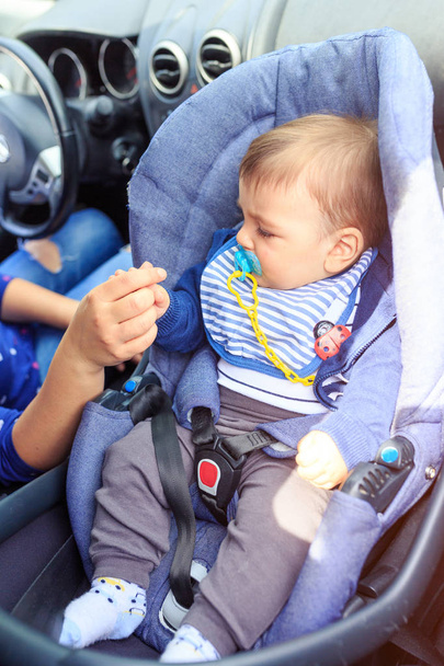 menino sentado na cadeira auto criança. Mãe e filho no carro. Condução de segurança
.  - Foto, Imagem