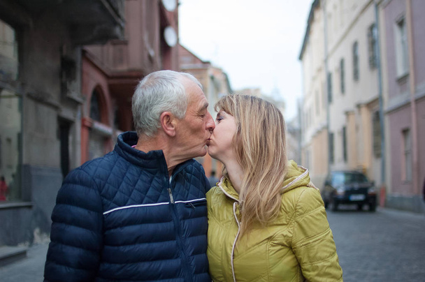 Onnellinen romanttinen pari ikäero suudella ulkona muinaisessa kaupungissa alkukeväästä tai syksystä
. - Valokuva, kuva
