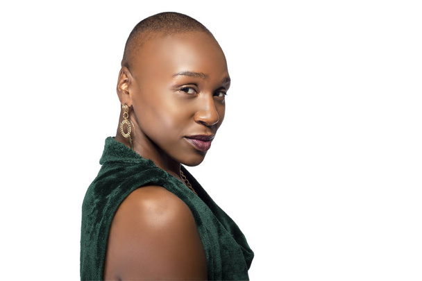 Beautiful black African American female model posing confidently with bald hairstyle on a white background.  The woman is portraying uniqueness and individuality.   - Foto, imagen