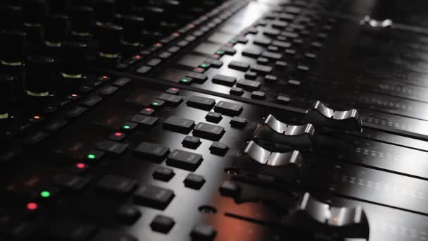 Sound engineer hand adjusting faders on a mixing console - Footage, Video