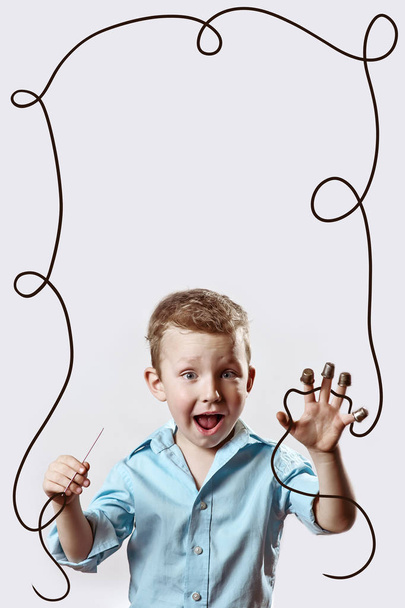 a boy with a needle and thread in a blue shirt on a light background - Photo, Image