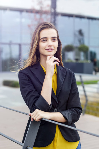 Portrait de jeune femme d'affaires debout en plein air devant le bâtiment de l'entreprise
 - Photo, image