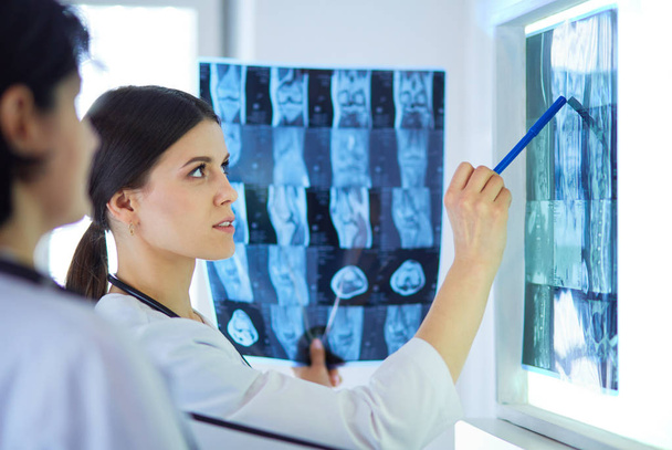 Two female doctors pointing at x-rays in a hospital - Foto, Bild