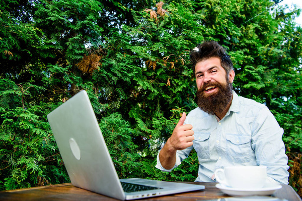 Wifi and laptop. Drink coffee and work faster. Bearded man successful freelance worker. Remote job. Freelance professional occupation. Good job expression. Well done. Hipster busy with freelance - Foto, immagini