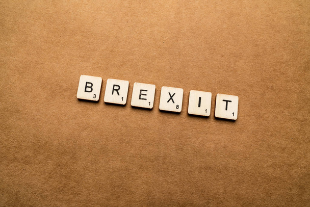 LONDON, UK - May 24 2019: The word BREXIT, spelt with wooden letter tiles over a brown textured background - Photo, Image