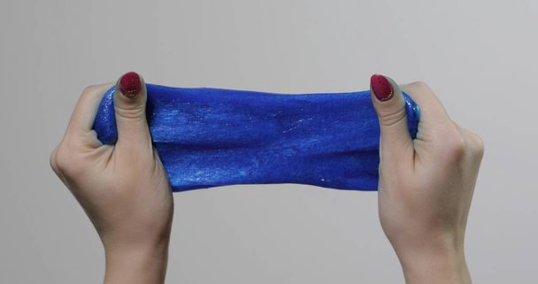 Mani donna giocando con stranamente soddisfacente sostanza appiccicosa melma blu. Antistress
 - Foto, immagini