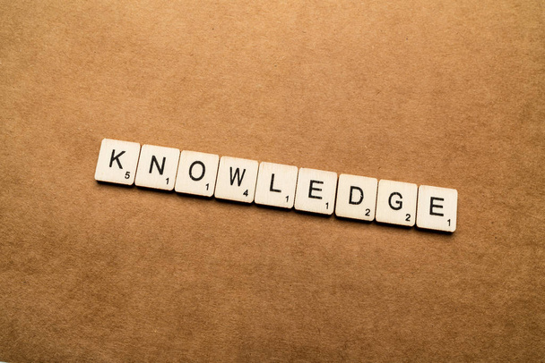 LONDON, UK - May 24 2019: The word KNOWLEDGE, spelt with wooden letter tiles over a brown textured background - Photo, Image