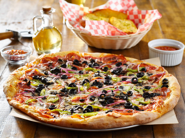 вкусная высшая пицца с луком оливкового перца и колбасой
 - Фото, изображение