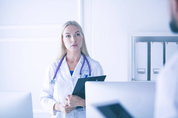 Woman doctor standing with folder at hospital - Fotoğraf, Görsel