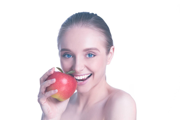 Portrait of happy smiling young beautiful woman eating red apple, over white background - Foto, Imagem