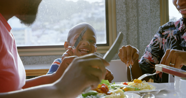 Front view of smiling African american family having food at dining table in a comfortable home. 4k - Πλάνα, βίντεο